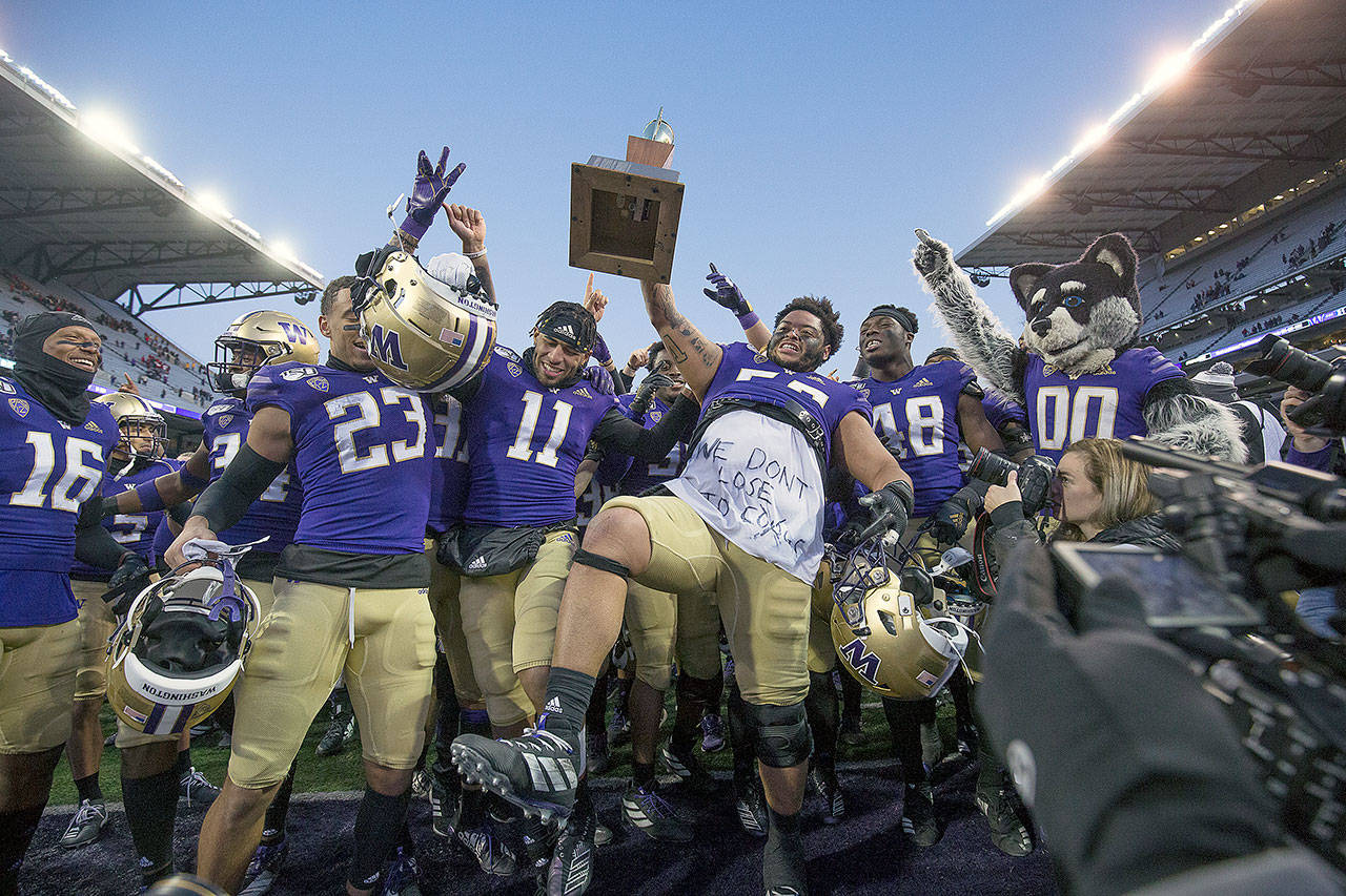University of Washington Huskies celebrate with the Apple Cup after beating Washington State University Cougars 31-13 the in the 112th Apple Cup at Husky Stadium on Friday, Nov. 29, 2019 in Seattle, Wash. (Andy Bronson / The Herald)