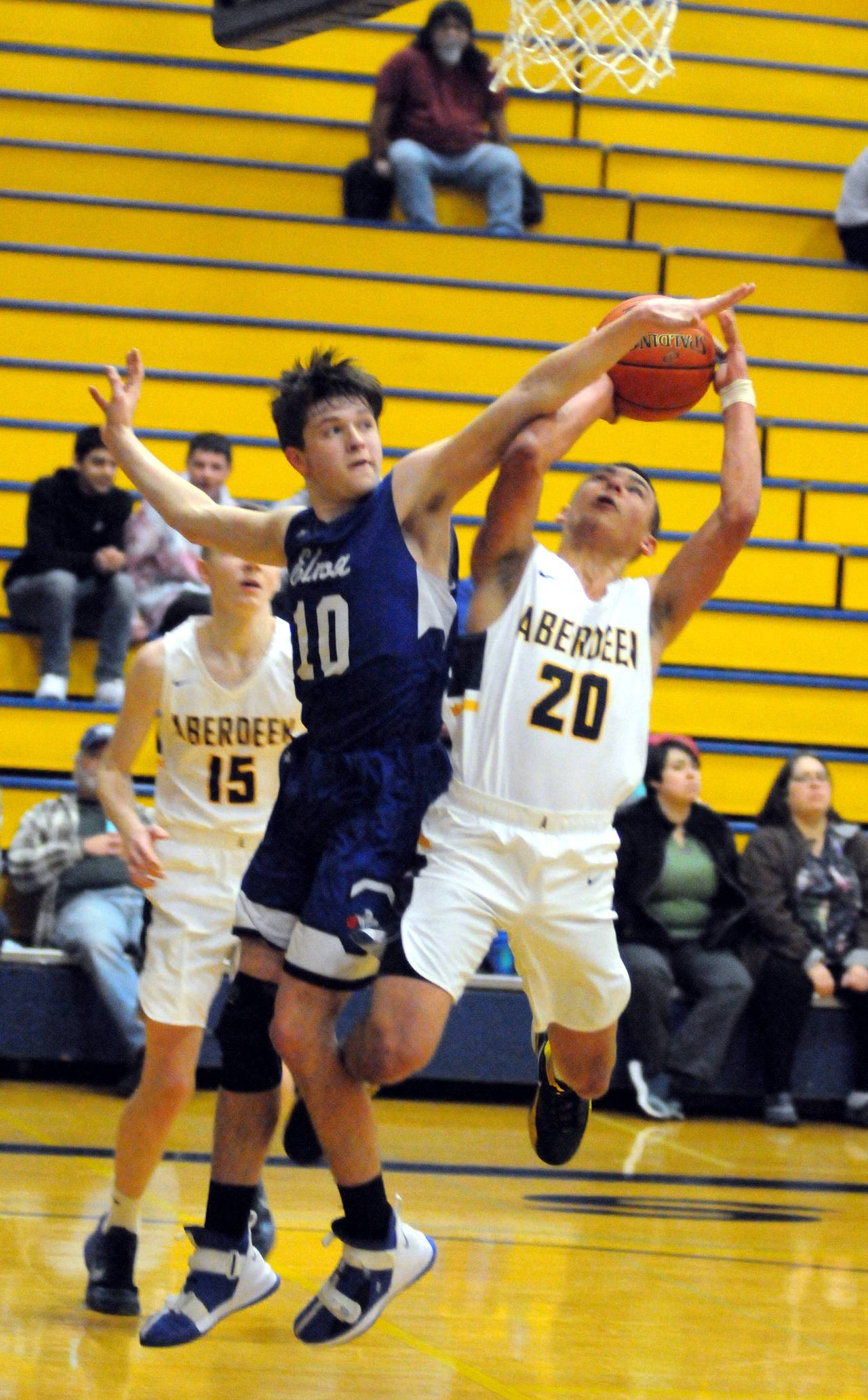 Aberdeen’s Ethan Morrill (20) is fouled by Elma’s Cobey Moore on a drive to the basket in the first half of Aberdeen’s 53-44 win on Tuesday in Aberdeen. (Ryan Sparks | Grays Habor News Group)