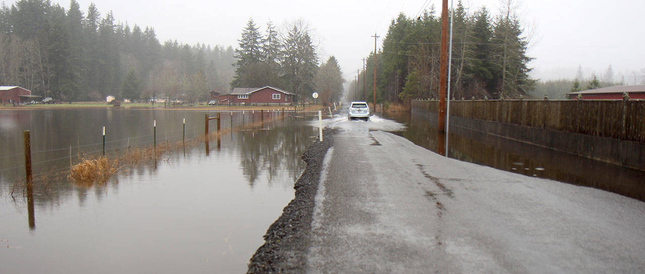 A vehicle drives Tuesday (Jan. 7, 2020) through water flowing over Newman Creek Road into a field near Satsop, Washington. The National Weather Service in Seattle issued a flood warning for the Satsop River on Tuesday morning. (Michael Lang | Grays Harbor News Group)