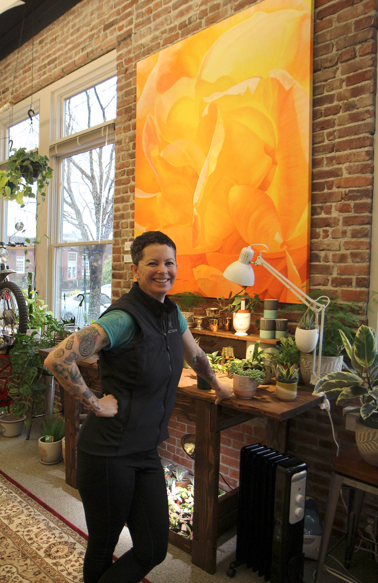 Trina Moore smiles while discussing her work Jan. 29 at her gallery, The Moore Gallery, in Montesano. The painting behind her recently sold for $5,400.