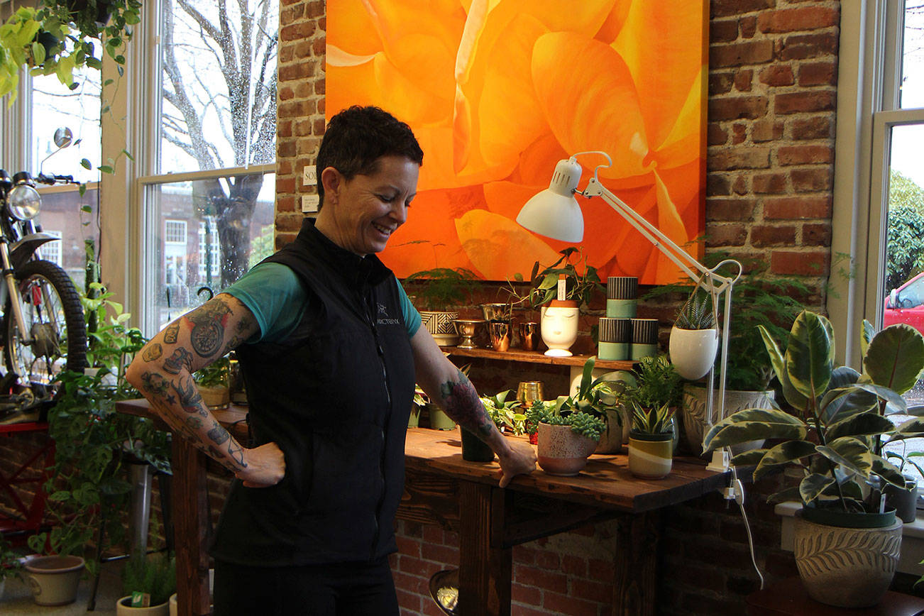 Trina Moore pauses while discussing her work Jan. 29, 2020, at her gallery, The Moore Gallery, in Montesano. The painting behind her recently sold for $5,400. (Michael Lang | Grays Harbor News Group)