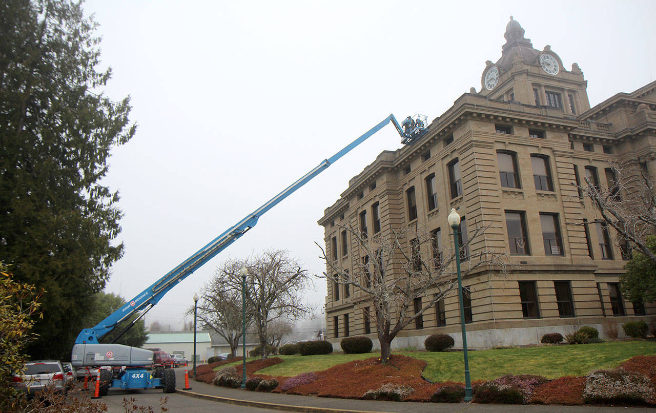 A crew from John Lupo Roofing works in the fog Thursday, Feb. 27, 2020, on the Grays Harbor County Courthouse, which has sprung a leak. The emergency exterior repairs were expected to finish before the end of the week. (Michael Lang | Grays Harbor News Group)