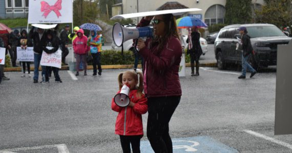Five-year old Aubrey Wolfe shouts “Where is Oakley?” into her bullhorn beside her mother Jordan Wolfe, at the Gathering for Oakley, on Saturday, April 9, outside the Grays Harbor County Jail, in Montesano. Oakley’s biological parents, Jordan Bowers and Andrew Carlson, are both inmates inside the jail. (Matthew N. Wells | The Daily World)