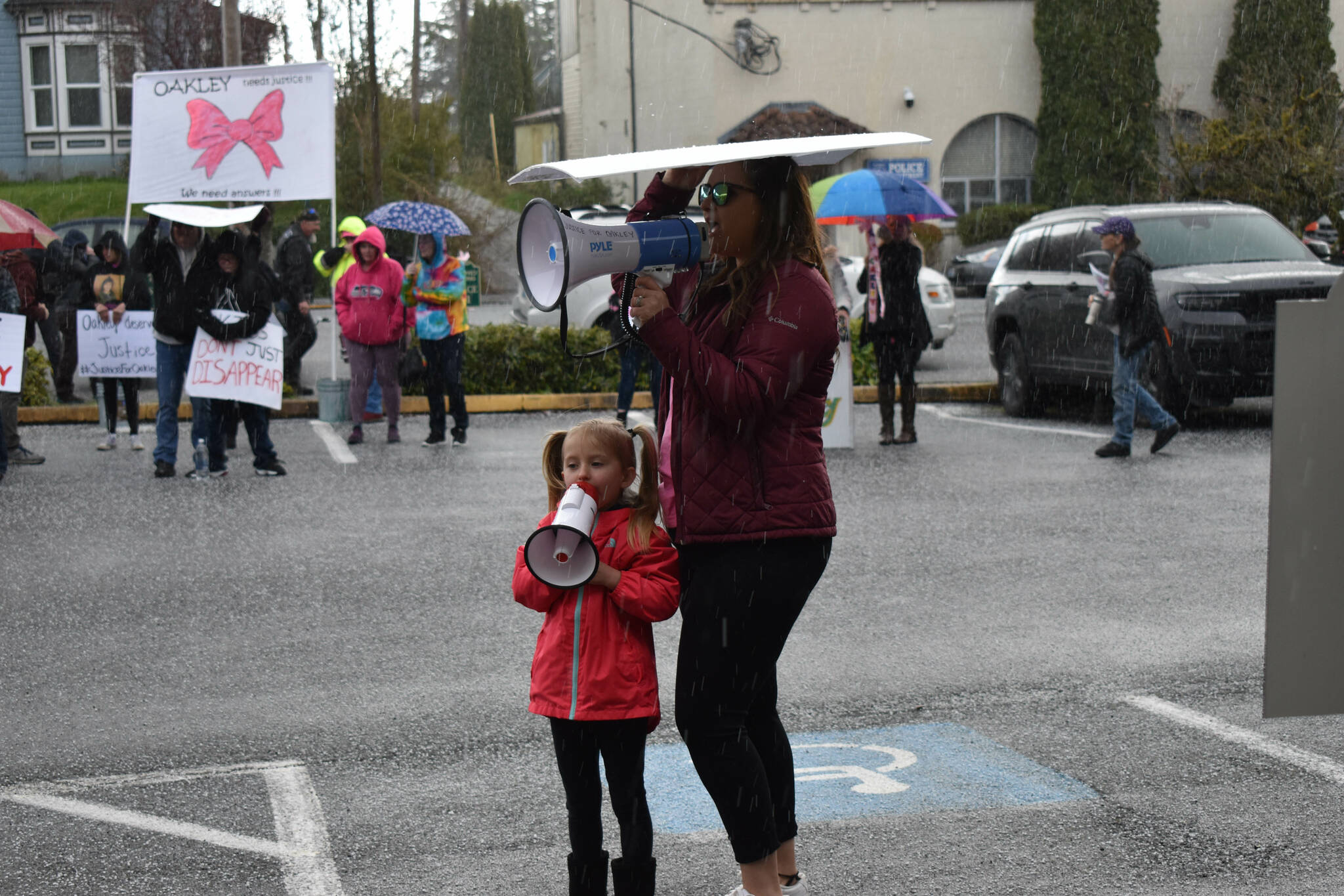Five-year old Aubrey Wolfe shouts “Where is Oakley?” into her bullhorn beside her mother Jordan Wolfe, at the Gathering for Oakley, on Saturday, April 9, outside the Grays Harbor County Jail, in Montesano. Oakley’s biological parents, Jordan Bowers and Andrew Carlson, are both inmates inside the jail. (Matthew N. Wells | The Daily World)