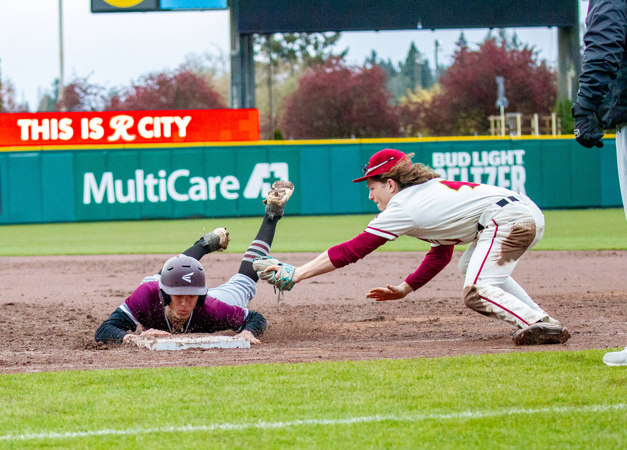 PHOTO BY SHAWN DONNELLY Montesano’s Jackson Busz dives back into first base during the Bulldogs’ 9-5 loss to Jefferson on Saturday at Cheney Stadium in Tacoma.