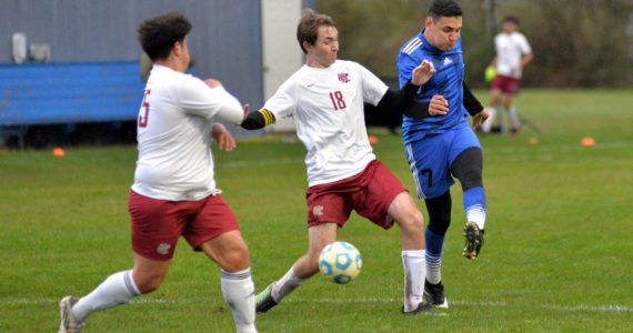 RYAN SPARKS | THE DAILY WORLD Elma midfielder Valencia Mendoza, right, scores on a shot while being defended by Hoquiam senior Kolby Skolrood during Elma’s 9-0 win on Wednesday at Davis Field in Elma. Mendoza scored five goals and had two assists in the game.