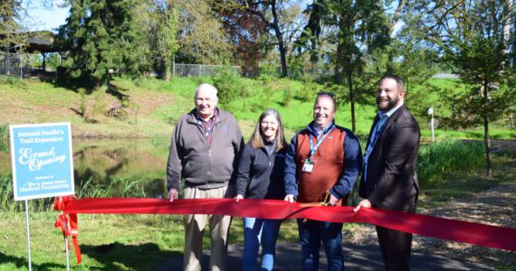 Summit Pacific Medical Foundation President Brian Smith (holding scissors) stands alongside foundation board members and Summit Pacific CEO Josh Martin (right) to celebrate the grand opening of the newest addition of the trail expansion at the hospital campus on May 20, 2022, in Elma. (Photo Courtesy of Nichole Pas)