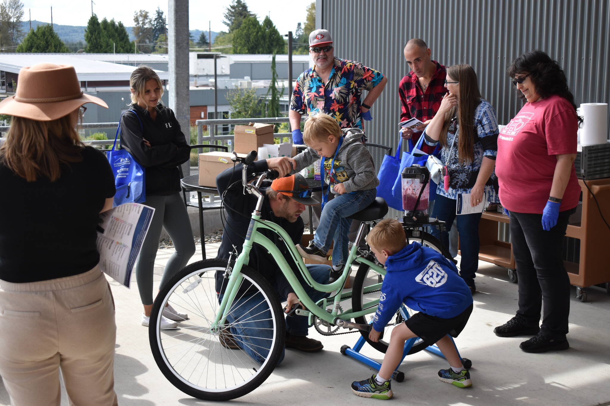 (Allen Leister | The Daily World)
                                Families patiently waited in line for their chance to use the smoothie-making bicycle at the Summit Pacific Peak Health Fair, on Saturday, Sept. 17, in Elma. The custom-made bicycle, which will be present at every future Summit Pacific event, was obtained via a $1,000 grant.